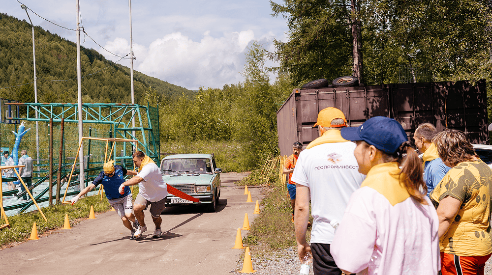 Слайд 3: Конкурс, мужчины тянут автомобиль за трос
